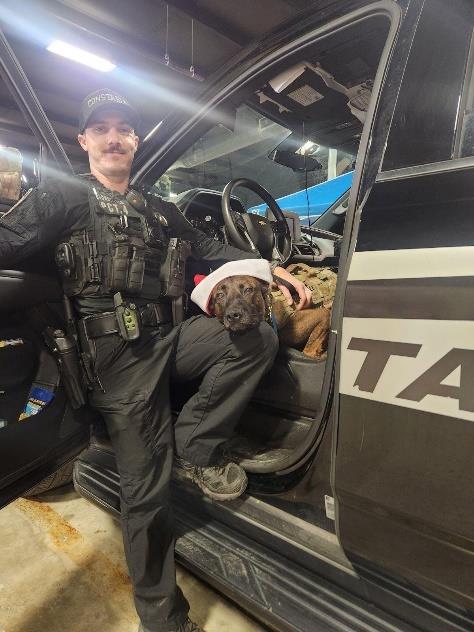 Photo of K9 Deputy and his dog wearing a Santa hat. 